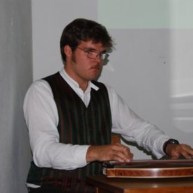 Mann mit Brille sitzt an Tisch