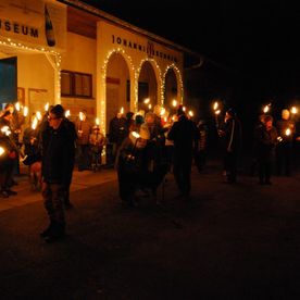 Beleuchtetes Museum hinter feierlicher Menschenversammlung