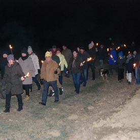 Menschenumzug nachts mit Fackeln