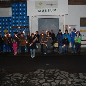 Menschen mit Fackeln vor Museumseingang