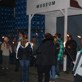 Menschen mit Fackeln vor Museum